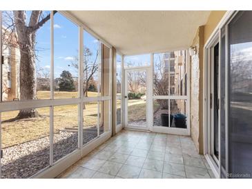 Bright sunroom with tiled floor and sliding door access to the outside with lovely view at 3082 S Wheeling Way # 106, Aurora, CO 80014
