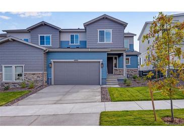 Charming two-story home with a blue-gray color scheme and a well-manicured front yard at 6882 Oak Canyon Cir, Castle Pines, CO 80108