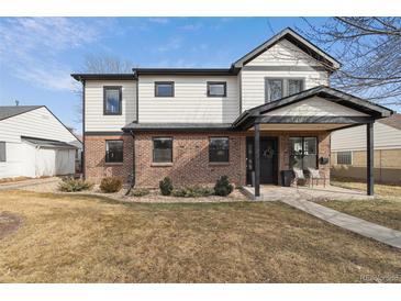 Charming two-story home featuring a brick facade, white siding, and a welcoming covered front porch at 2480 Quitman St, Denver, CO 80212