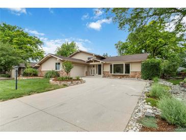 Charming ranch-style home with lush landscaping, stone accents and a large driveway at 6581 E Heritage Pl, Englewood, CO 80111