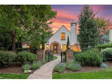 Charming Tudor-style home with stone walkway, manicured lawn, and mature landscaping at dusk at 5530 E 6Th Ave Pkwy, Denver, CO 80220