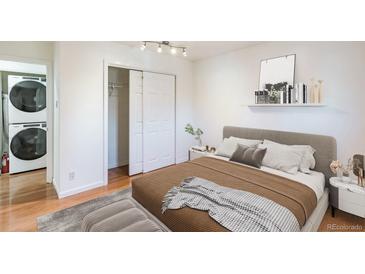 This bedroom features a modern design with a comfortable bed, closet, and stacked washer and dryer at 1250 S Monaco Pkwy # 44, Denver, CO 80224