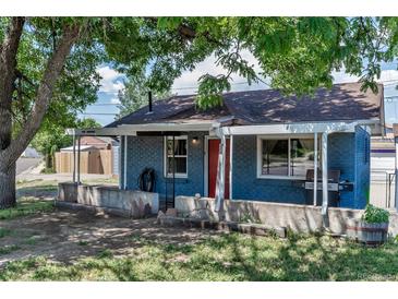 Charming brick home featuring a covered porch, red front door, and mature trees at 3151 N Elizabeth St, Denver, CO 80205