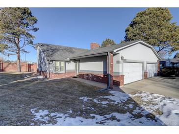 Ranch style home with a two-car garage and landscaped yard at 5222 S Emporia Way, Greenwood Village, CO 80111