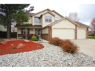 Charming two-story home featuring a well-manicured front yard with mature trees at 17722 E Ida Ave, Centennial, CO 80015