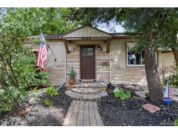 Charming stone home with a well-maintained landscaped yard and American flag at 2680 S Garfield Cir, Denver, CO 80210