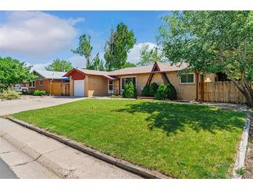 Charming single-story home with a well-maintained lawn and mature trees, showcasing its inviting curb appeal at 5920 Garrison St, Arvada, CO 80004