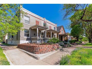 Charming multi-story home featuring a landscaped front yard and a classic brick facade with a welcoming covered porch at 2566 N Emerson St, Denver, CO 80205