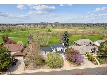Aerial view of home near a golf course with mature trees and manicured lawns on a sunny day at 12391 E Cedar Cir, Aurora, CO 80012