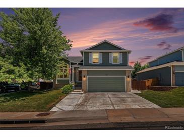 Charming two-story home with a well-manicured lawn, mature tree, and an inviting two-car garage at 5102 S Lisbon Way, Centennial, CO 80015
