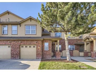 Charming two-story townhouse features brick accents, attached garage and a well-maintained lawn at 8915 Federal Blvd # 203, Denver, CO 80260