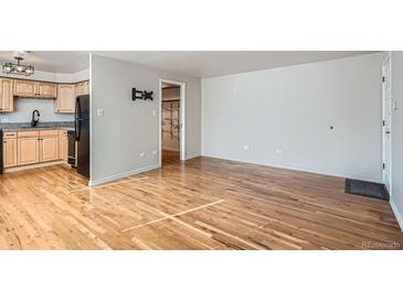 Bright living room with hardwood floors flowing into an open kitchen area, ideal for entertaining and everyday living at 985 N Corona St # 204, Denver, CO 80218