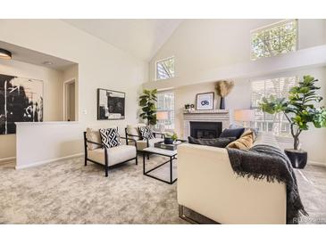 Bright living room showcasing vaulted ceilings, fireplace, and neutral modern furniture arrangement at 5016 S Nelson St # C, Littleton, CO 80127