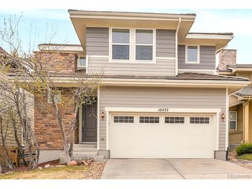 Beautiful two-story home with a two-car garage, stone accents, and a well-maintained front yard at 10452 Rutledge St, Parker, CO 80134