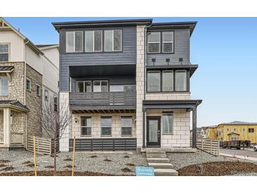 Modern three-story home featuring a second-story balcony and a textured facade at 8866 Waterleaf Ln, Littleton, CO 80125