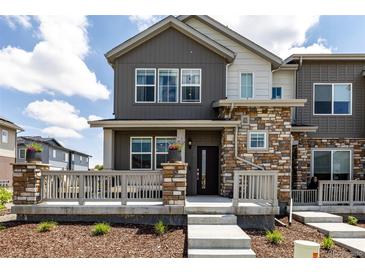 Charming townhome featuring stone accents, gray siding, and a cozy front porch at 1500 Sun Way, Lafayette, CO 80026