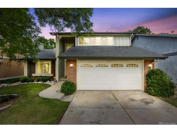 Charming two-story home with a brick facade and well-maintained lawn and a two car garage at 3889 S Fraser St, Aurora, CO 80014