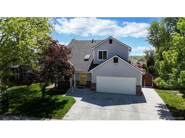 Charming two-story home featuring a well-manicured lawn, mature trees, and a welcoming facade at 10635 Dexter Dr, Thornton, CO 80233
