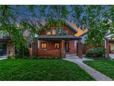 Charming brick two-story home with a well-manicured front lawn and inviting curb appeal at 890 S Vine St, Denver, CO 80209