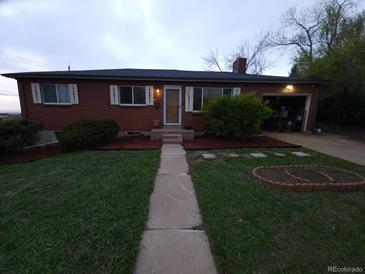 Charming brick home with a well-manicured front yard and a welcoming walkway leading to the front door at 12024 W Maryland Dr, Lakewood, CO 80228