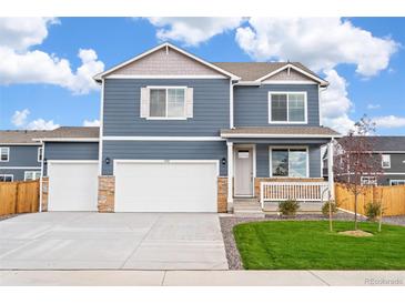 Charming two-story blue home featuring a three car garage, small porch, and manicured lawn at 262 Chardon Ave, Brighton, CO 80601