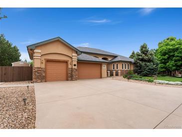 Charming home boasting a three-car garage, stone accents, and a spacious driveway at 3806 S Dawson St, Aurora, CO 80014