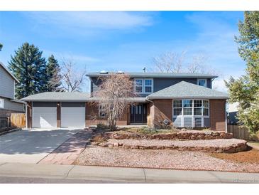 Charming two-story home with brick accents, a two-car garage, and a well-maintained front yard at 7746 S Harrison Cir, Centennial, CO 80122