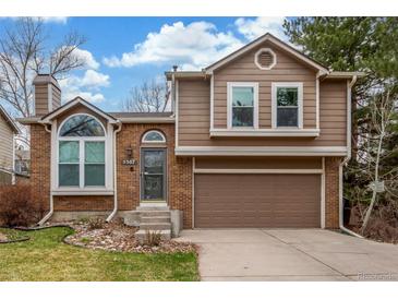 Two-story home featuring brick and wood siding, a two car garage, and a well-manicured lawn at 5307 E Courtney Ave, Castle Rock, CO 80104