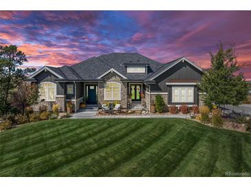 Charming home with a stone and gray facade, manicured lawn, and seating area at 9563 Red Primrose St, Franktown, CO 80116