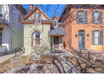 Charming Victorian-style home with a unique arched window and inviting front porch at 2543 Stout St, Denver, CO 80205