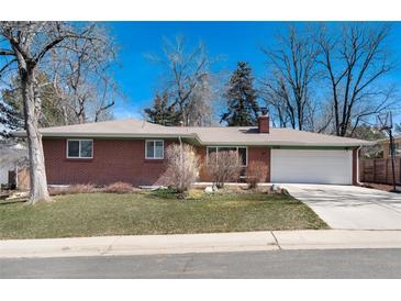 Cozy brick home featuring an attached two-car garage and a well-maintained front yard at 6930 S Delaware St, Littleton, CO 80120