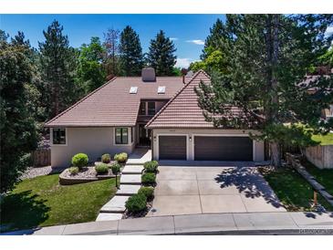 Charming home with a terracotta tile roof, an attached two car garage, and mature landscaping at 5672 S Hanover Way, Greenwood Village, CO 80111