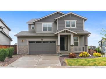 Charming two-story home with a gray exterior, two-car garage, and landscaped front yard at 9479 Rifle St, Commerce City, CO 80022