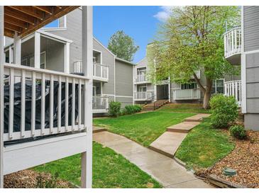 Exterior view of apartments surrounded by well-maintained grass and walkways at 4460 S Pitkin St # 119, Aurora, CO 80015