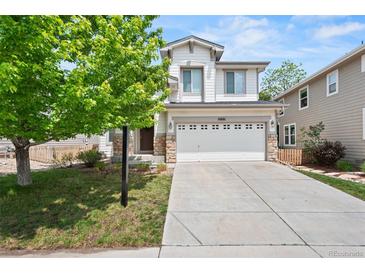 Charming two-story home boasts stone accents, a well-manicured lawn, and a spacious two-car garage at 10681 Cherrybrook Cir, Highlands Ranch, CO 80126