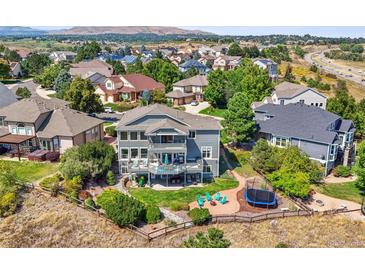 Expansive backyard with a patio, lawn, and trampoline, perfect for outdoor activities and entertaining with great views at 10520 W Vassar Dr, Lakewood, CO 80227