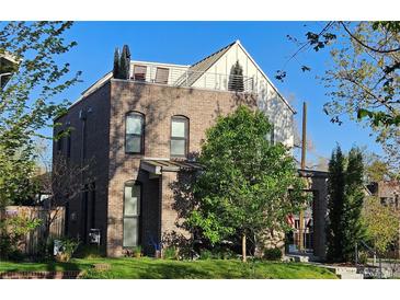 Stunning exterior of a brick home with a rooftop terrace and mature trees at 501 S Race St, Denver, CO 80209
