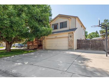 Charming two-story home featuring a well-manicured lawn, large tree, and a spacious driveway at 3838 S Waco St, Aurora, CO 80013