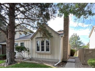 Charming home featuring a brick chimney, mature trees, and a well-maintained front yard at 9610 W Chatfield Ave # F, Littleton, CO 80128