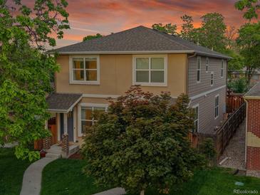Two-story home with neutral siding, mature trees, well-kept lawn and inviting walkway leading to the front door at 3612 Hudson St, Denver, CO 80207