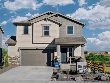 Charming two-story home with a covered front porch, neutral siding and a two-car garage at 903 W Beverly St, Elizabeth, CO 80107