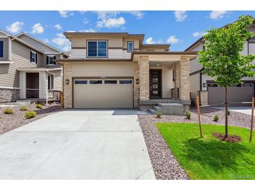 Beautiful two-story home featuring a two car garage and stone pillar accents at 9266 Telluride Ct, Commerce City, CO 80022