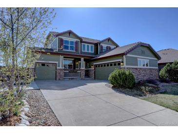 Charming two-story home with a three car garage, stone accents, and well-manicured landscaping at 11918 S Hitching Post Trl, Parker, CO 80134