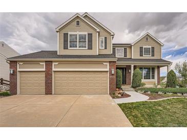 Charming two-story home with a three-car garage, brick accents, and a well-manicured lawn at 18225 E Caley Dr, Aurora, CO 80016