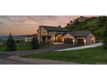 Beautiful two-story home with three-car garage, manicured lawn, and a scenic mountain view at 6402 Wauconda Dr, Larkspur, CO 80118