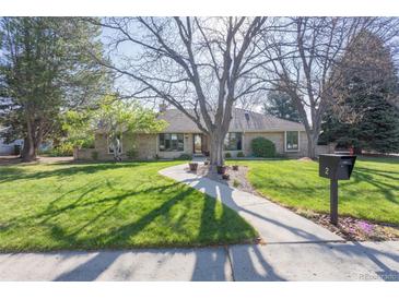Charming brick home with a well-manicured lawn, mature trees and a welcoming walkway to the front door at 2 Larkdale Dr, Littleton, CO 80123