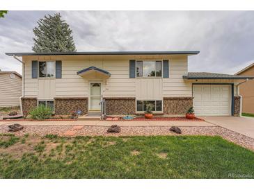 Charming home with a well-maintained lawn, brick accents, and inviting curb appeal at 744 Memphis St, Aurora, CO 80011