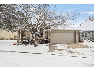 Brick ranch home with attached garage, snow-covered landscaping, and mature trees at 7329 Windsor Dr, Boulder, CO 80301