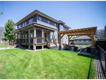 Inviting backyard featuring a pergola-covered dining area, spacious lawn, and a two-story deck at 4180 Kalamath St, Denver, CO 80211