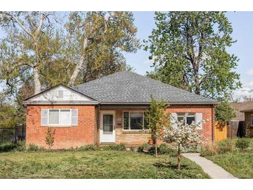 Charming brick home featuring a well-maintained front yard, blossoming trees, and cozy curb appeal at 1610 Xanthia St, Denver, CO 80220